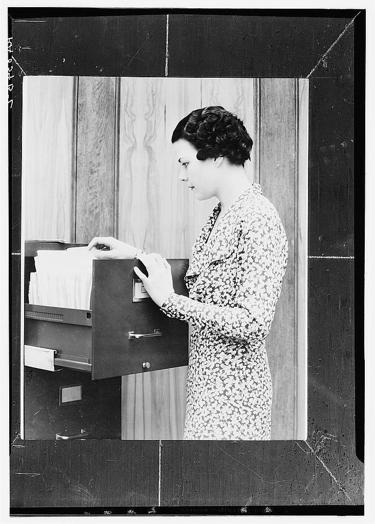 A woman worker at a filing cabinet organizing office records